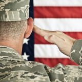 Military soldier saluting American flag